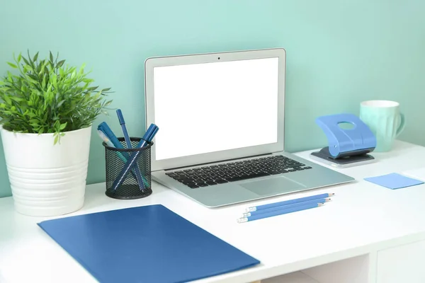 Kényelmes munkahely modern laptoppal a kék fal közelében — Stock Fotó