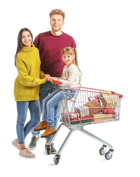 白い背景にクリスマスの贈り物でいっぱいのショッピングカートを持つ家族 — ストック写真