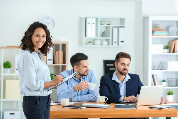 Jeune femme d'affaires avec ses partenaires en fonction — Photo