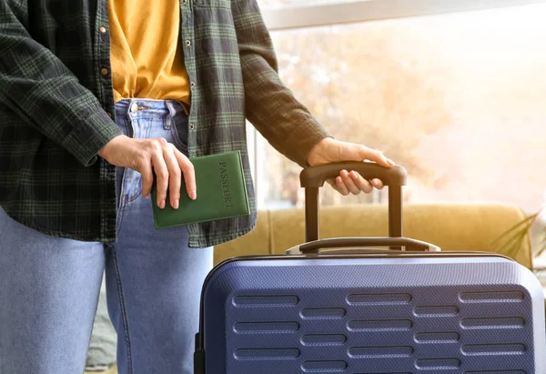 Young woman with packed suitcase and passport at home — Stock Photo, Image