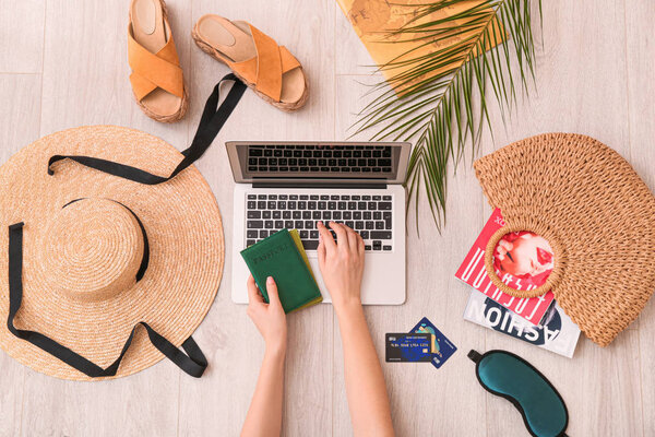 Woman with laptop visiting travel agency website, top view