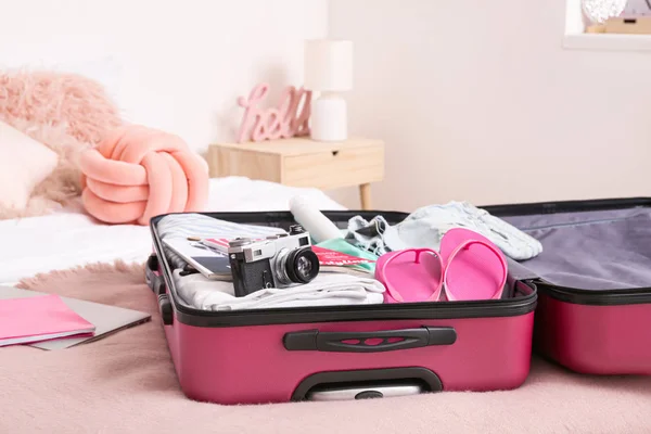 Open suitcase with packed clothes and accessories on bed — Stock Photo, Image