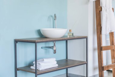 Renk duvarının yanında lavabosu olan temiz bir banyo.