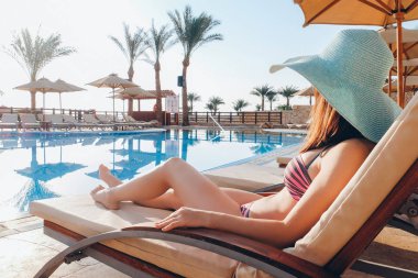 Tatil köyünde yüzme havuzunun yanında güzel genç bir bayan.