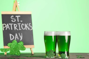 Üzerinde Aziz Patrick Günü yazılı yeşil bira ve yemek bardakları.
