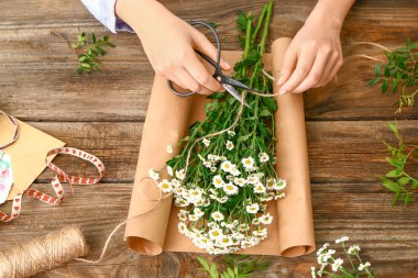 Kadın çiçekçi güzel buket üzerinde ahşap arka plan yapma