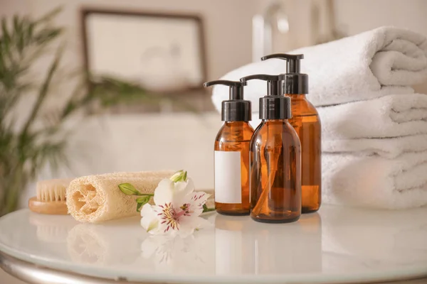 Clean towels with cosmetics and supplies on table in bathroom — 스톡 사진