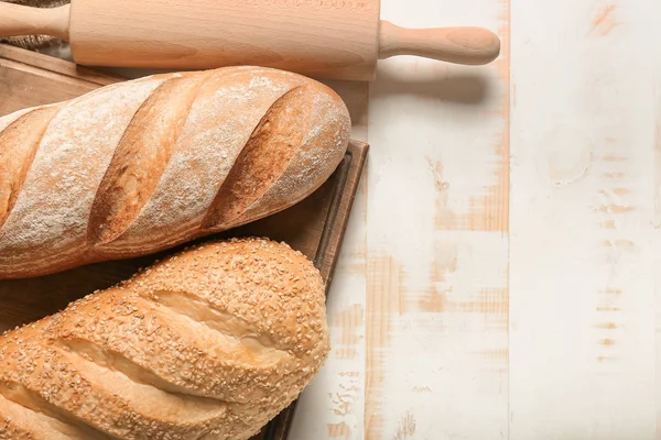 Sortimento de pão fresco com rolo de pino na mesa — Fotografia de Stock