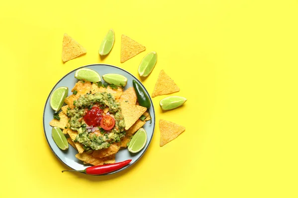 Plate with tasty nachos and guacamole on color background — Stock Photo, Image