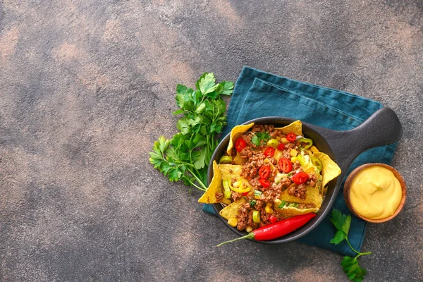 Frying pan with tasty chili con carne and nachos on grey background — Stock Photo, Image