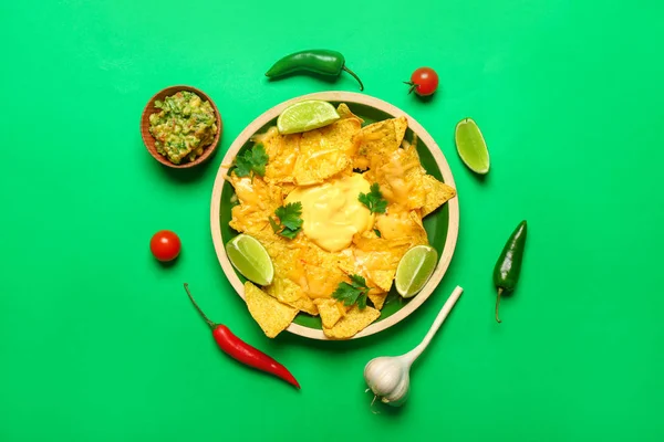 Placa con sabrosos nachos y guacamole sobre fondo de color — Foto de Stock