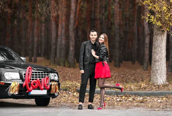 Joyeux jeune couple près de la voiture à l'extérieur. Fête de la Saint-Valentin — Photo