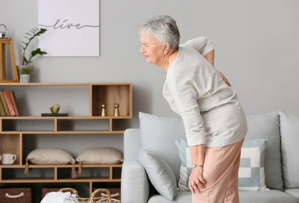 Senior woman suffering from back pain at home — Stock Photo, Image