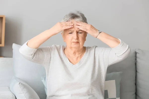 Oudere vrouw die thuis hoofdpijn heeft — Stockfoto