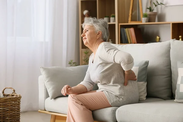 Старша жінка страждає від болю вдома — стокове фото