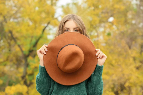 Stylowa młoda kobieta z kapeluszem w jesiennym parku — Zdjęcie stockowe