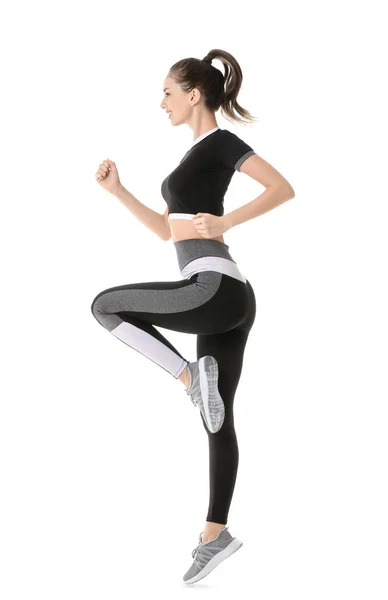 Sporty jumping young woman against white background — Stock Photo, Image