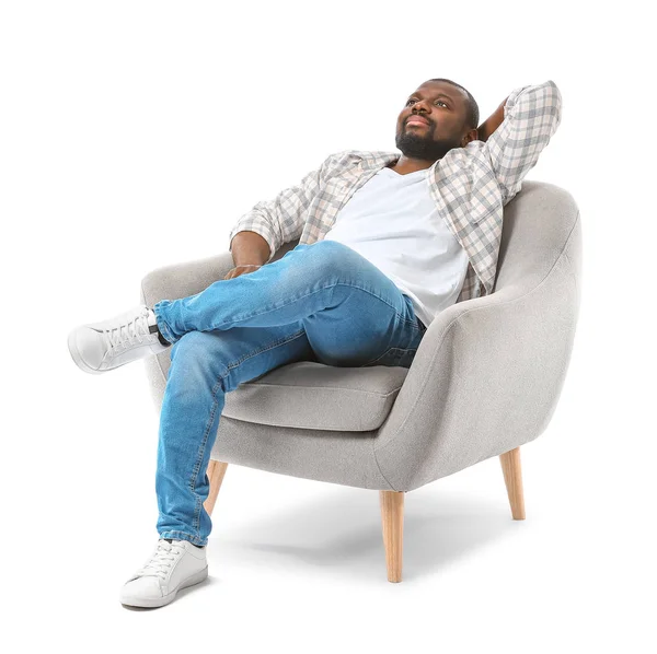 African-American man relaxing in armchair against white background — Stock Photo, Image