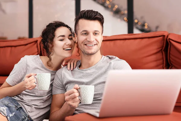Счастливая молодая пара с ноутбуком дома — стоковое фото
