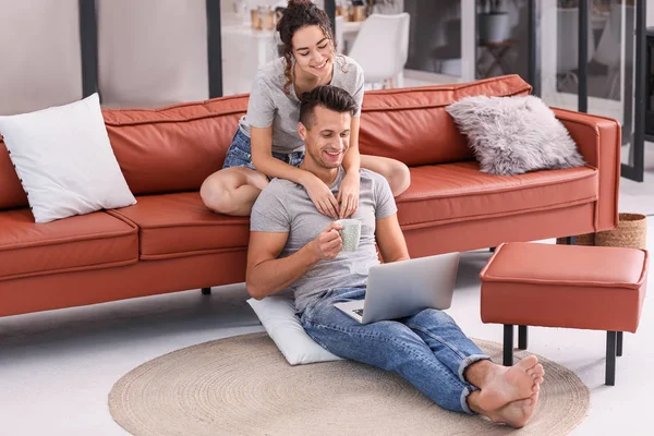 Feliz pareja joven con portátil en casa — Foto de Stock