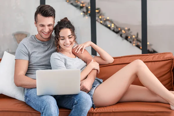 Feliz pareja joven con portátil en casa — Foto de Stock