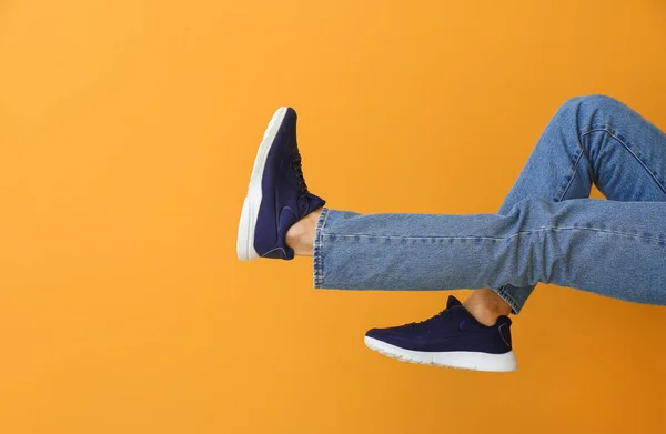 Hombre joven en zapatos elegantes en el fondo de color — Foto de Stock