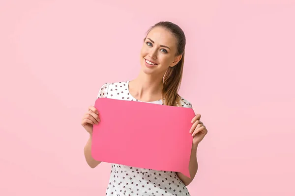 Young woman with blank speech bubble on color background — Stock Photo, Image