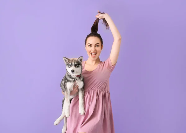 Cute woman with funny husky puppy on color background — Stock Photo, Image