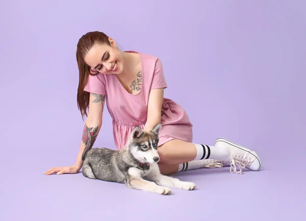 Cute woman with funny husky puppy on color background — Stock Photo, Image
