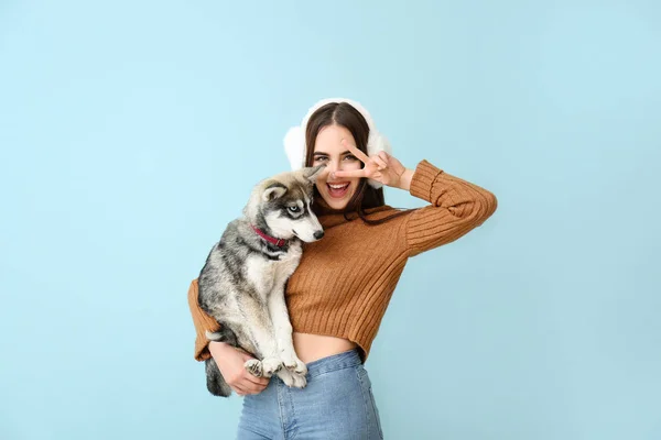 Cute woman with funny husky puppy on color background — Stock Photo, Image