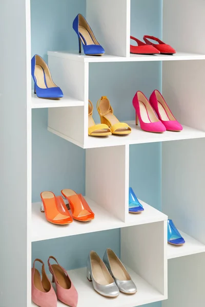 Półka z stylowymi butami w pobliżu ściany koloru — Zdjęcie stockowe