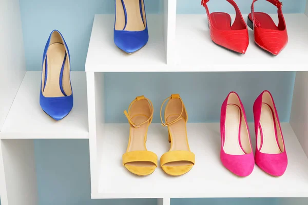 Półka z stylowymi butami w pobliżu ściany koloru — Zdjęcie stockowe