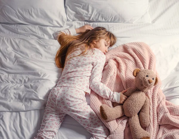 Yatakta uyuyan tatlı küçük kız. — Stok fotoğraf