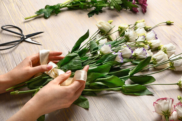 Female florist making beautiful bouquet at table