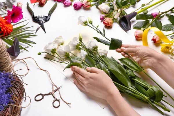 Female florist making beautiful bouquet on white background — Stock Photo, Image