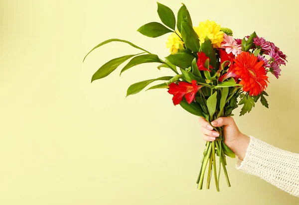 Hand of florist with beautiful bouquet on color background — Stock Photo, Image