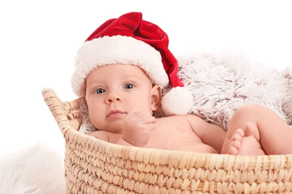 Bebê bonito com chapéu de Papai Noel deitado em cesta no fundo branco — Fotografia de Stock