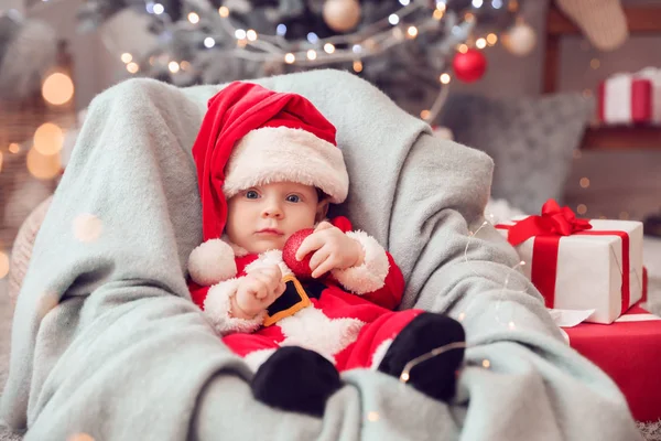 Bebê bonito em traje de Papai Noel em casa — Fotografia de Stock