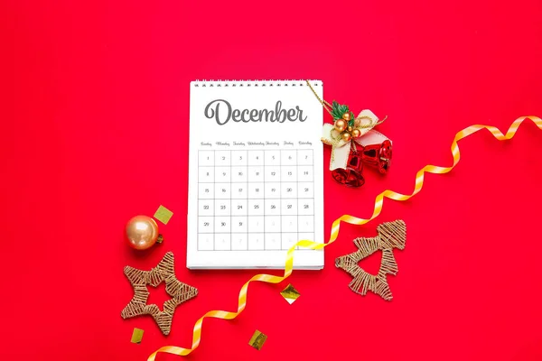 Calendar with page of December and Christmas decor on color background — Stock Photo, Image