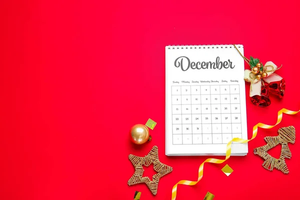 Calendario con página de diciembre y decoración navideña sobre fondo de color — Foto de Stock