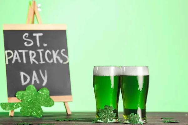 Sklenice zeleného piva a tabule s textem Den svatého Patrika na stole — Stock fotografie