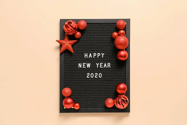 Placă cu text HAPPY NEW YEAR 2020 și decor pe fundal color — Fotografie, imagine de stoc