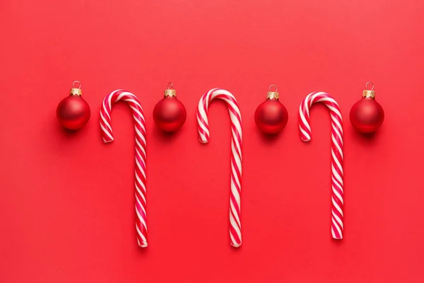 Beautiful Christmas balls with candy canes on color background — Stock Photo, Image