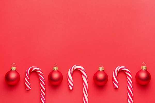 Beautiful Christmas balls with candy canes on color background — Stock Photo, Image