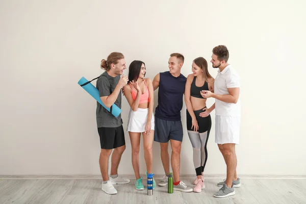 Group of sporty friends near white wall — Stock Photo, Image