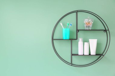 Shelf with bath supplies hanging on color wall clipart