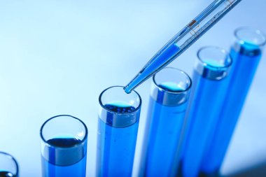 Test tüpüne renk örneği damlatılıyor, yakın plan.