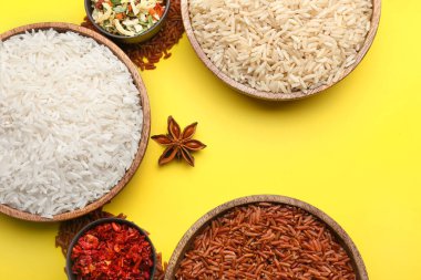 Farklı çiğ pirinç, sebze ve baharatlı tabaklar.