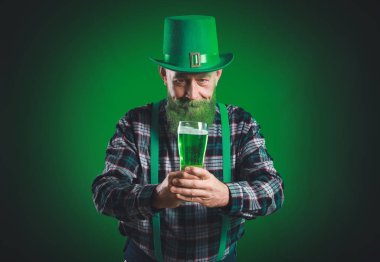 Siyah arka planda bir bardak birası olan komik olgun bir adam. Aziz Patrick Günü kutlaması