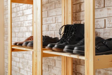 Tuğla duvarın yanında şık ayakkabılı raf ünitesi